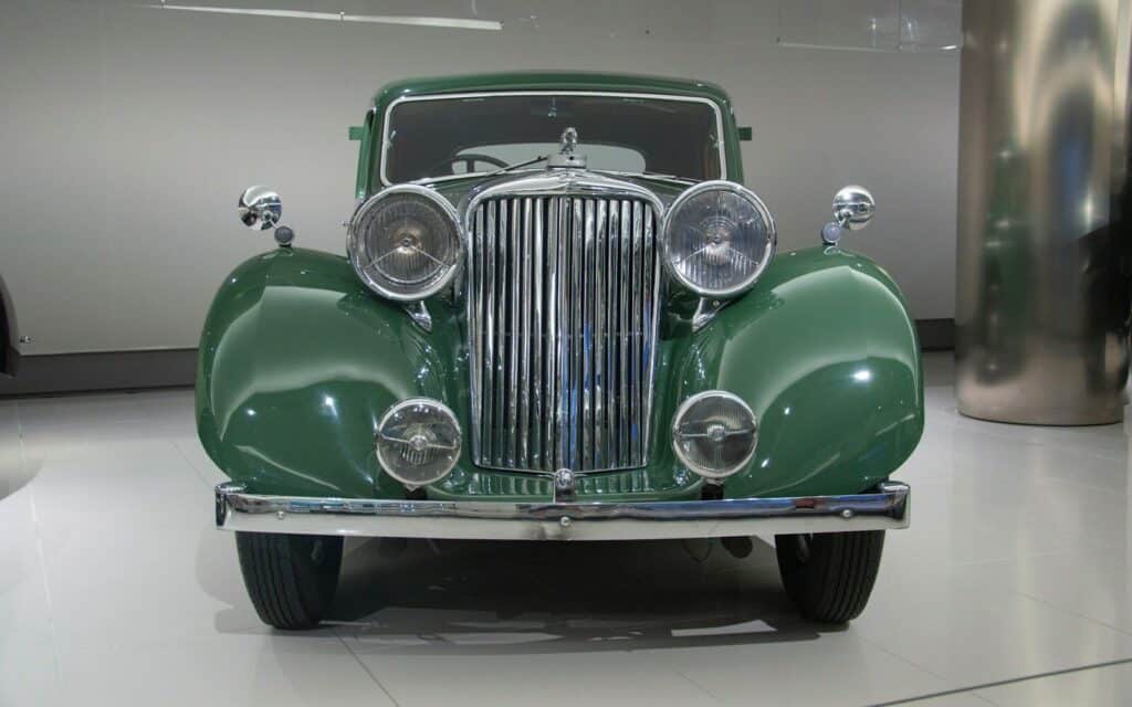 Photo by Frédéric LO BRUTTO an old green car is on display in a museum
